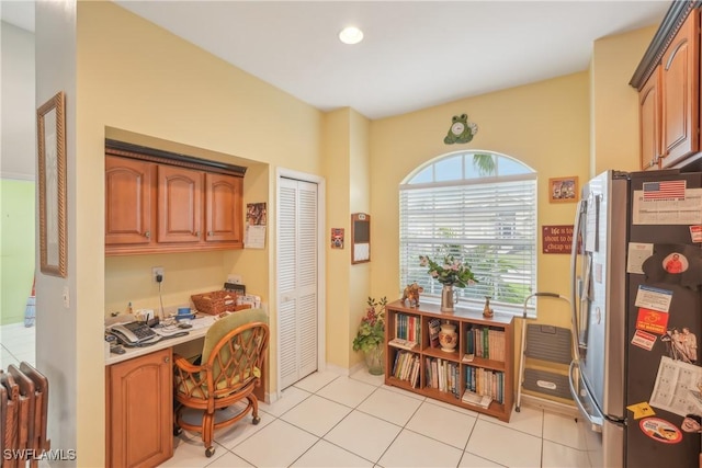 home office with radiator, built in desk, and light tile patterned floors