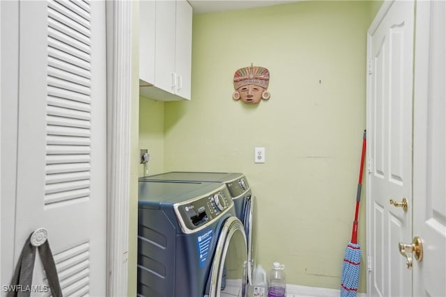 washroom with cabinets and washing machine and dryer