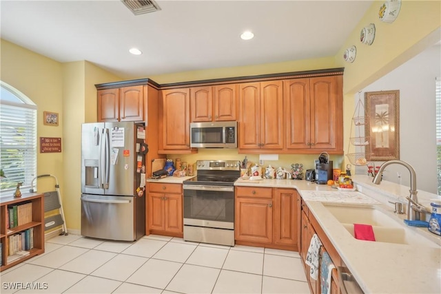 kitchen with light tile patterned flooring, stainless steel appliances, and sink