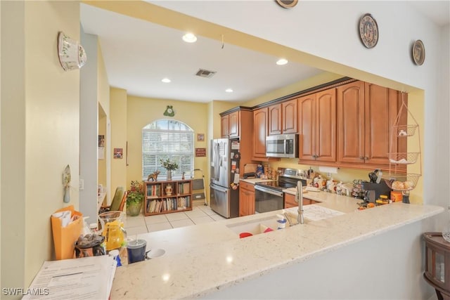 kitchen with light stone counters, stainless steel appliances, sink, and light tile patterned floors