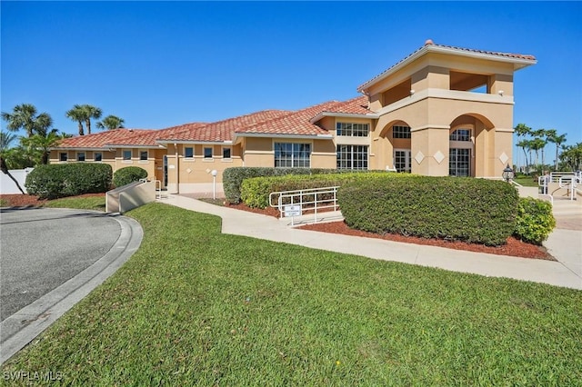 mediterranean / spanish house with a front yard