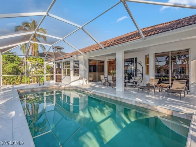 view of pool with glass enclosure and a patio area