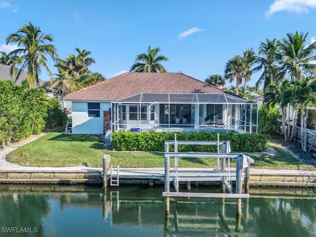 back of house featuring a yard, a water view, and a lanai