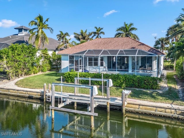 rear view of house featuring a yard, a water view, and glass enclosure