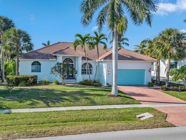 mediterranean / spanish-style home featuring a garage and a front lawn