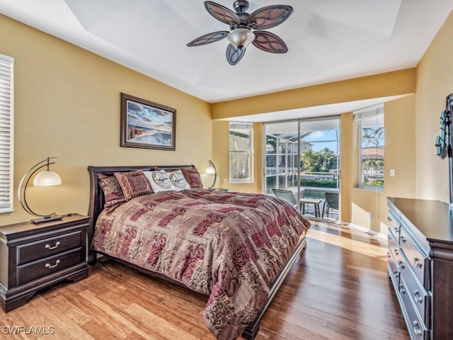 bedroom featuring access to exterior, ceiling fan, and dark wood-type flooring