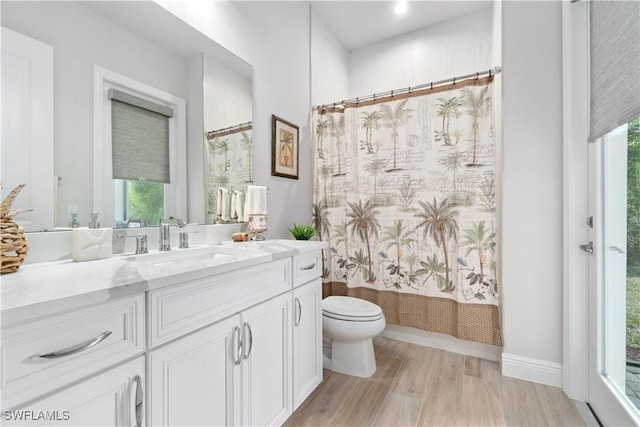 full bathroom featuring toilet, vanity, wood-type flooring, and shower / tub combo with curtain