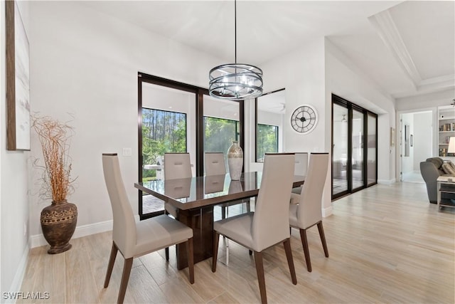 dining area with light hardwood / wood-style floors and a notable chandelier