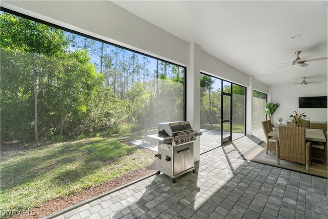 sunroom / solarium featuring ceiling fan