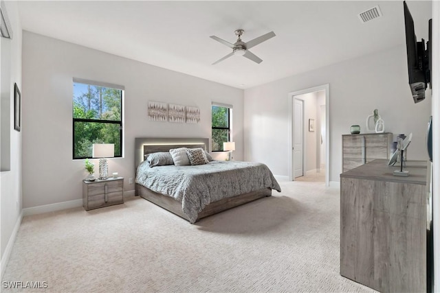 carpeted bedroom with ceiling fan and multiple windows