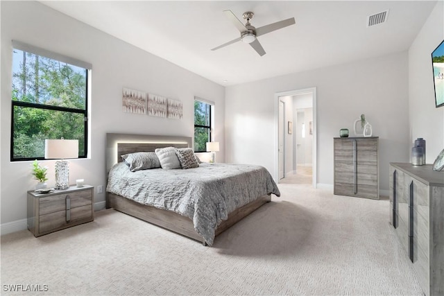 carpeted bedroom with ceiling fan and ensuite bath