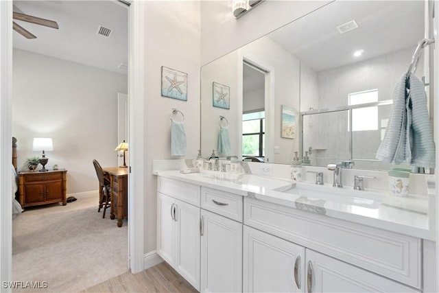 bathroom featuring ceiling fan, a shower with shower door, and vanity