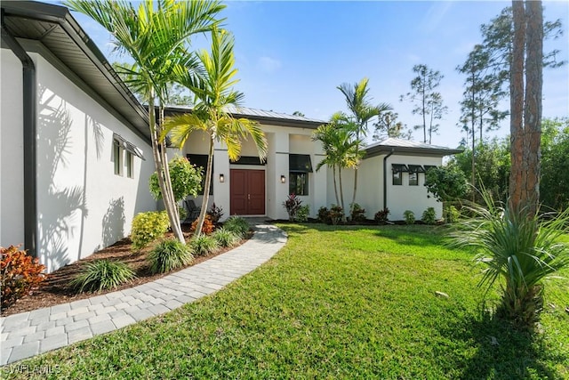 doorway to property featuring a lawn