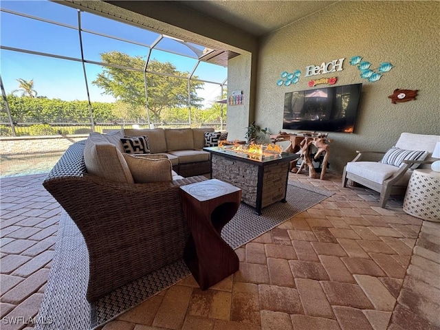 view of patio with an outdoor living space with a fire pit and glass enclosure