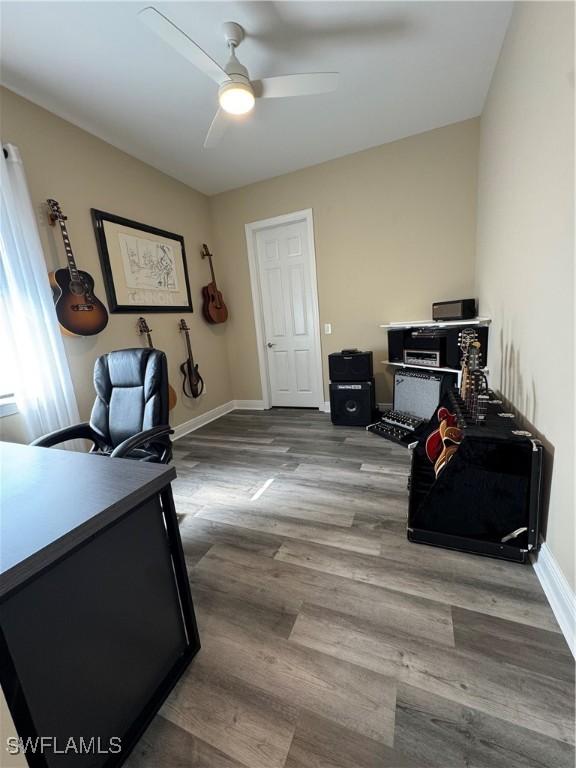 home office with ceiling fan and light hardwood / wood-style flooring