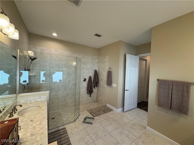 bathroom featuring tiled shower, vanity, and tile patterned floors