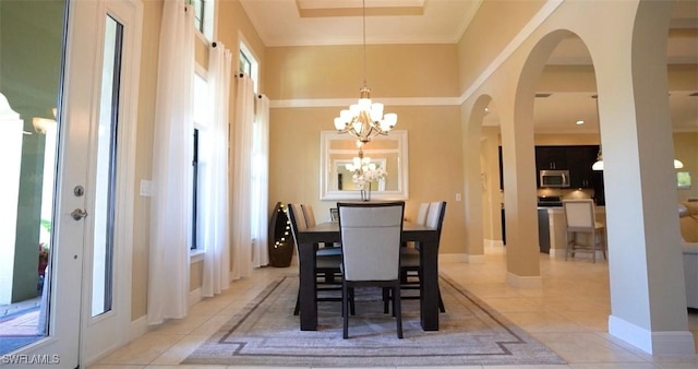 dining room with ornamental molding, a chandelier, and light tile patterned floors