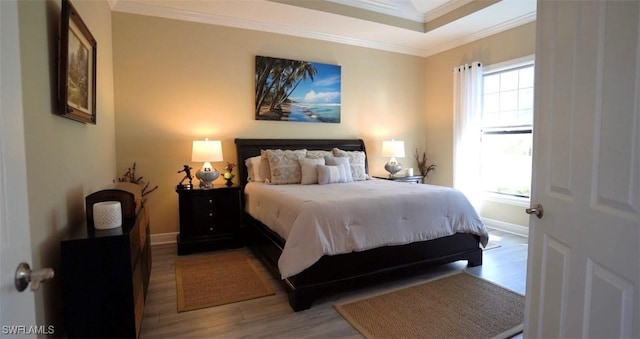 bedroom featuring light hardwood / wood-style floors and crown molding