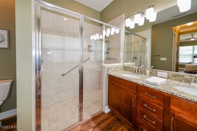 bathroom featuring vanity, toilet, a shower with door, and hardwood / wood-style floors