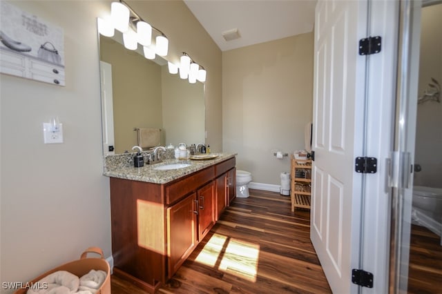 bathroom featuring vanity, hardwood / wood-style floors, and toilet