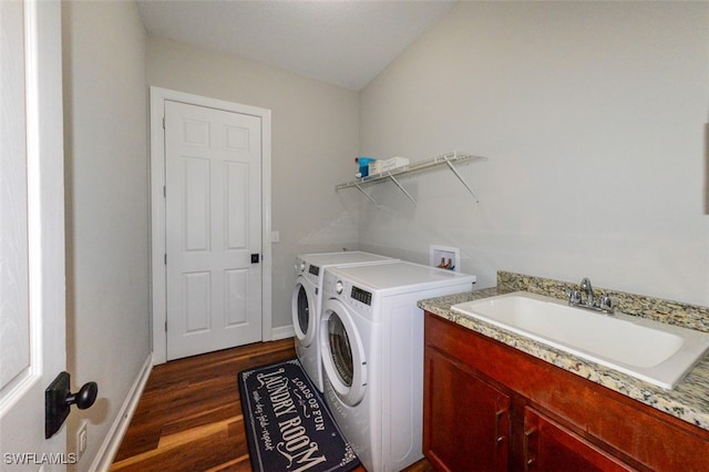 laundry area featuring washer and dryer, sink, and dark hardwood / wood-style flooring