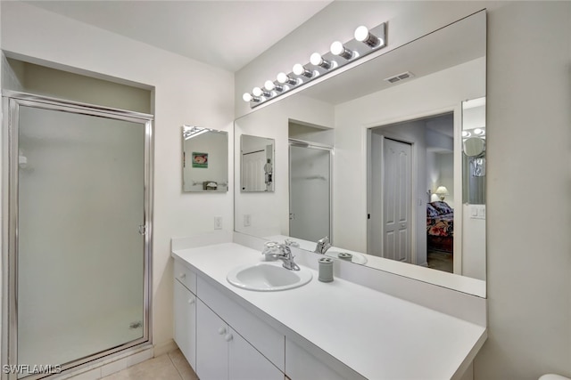 bathroom featuring a shower with door, tile patterned floors, and vanity