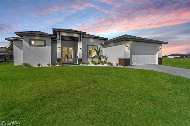 view of front of house featuring a garage and a yard