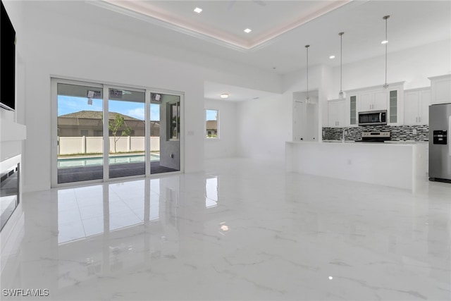 unfurnished living room featuring a raised ceiling