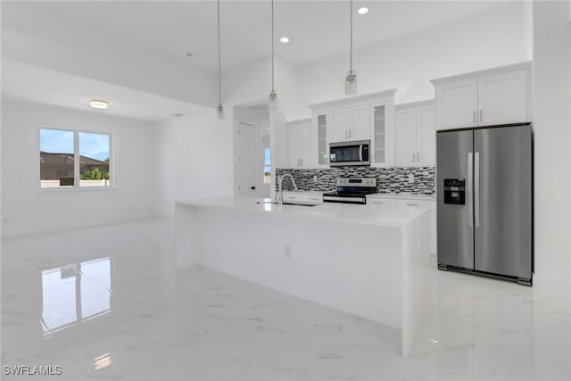 kitchen featuring backsplash, white cabinets, sink, hanging light fixtures, and appliances with stainless steel finishes