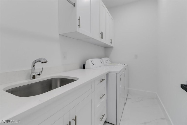 washroom with washing machine and clothes dryer, sink, and cabinets