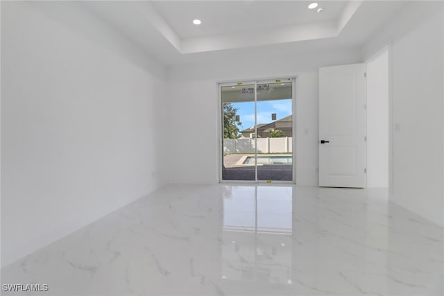 empty room featuring a raised ceiling