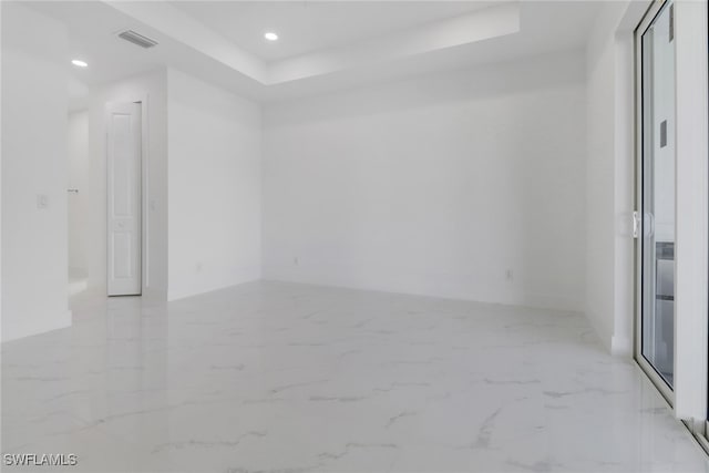 unfurnished room with a tray ceiling