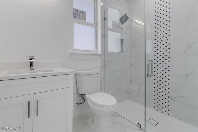 bathroom with vanity, toilet, and a shower with door