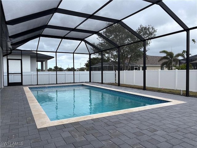 view of swimming pool with a patio and glass enclosure