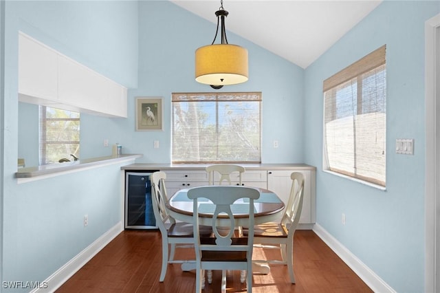 dining room featuring dark hardwood / wood-style flooring, beverage cooler, and vaulted ceiling