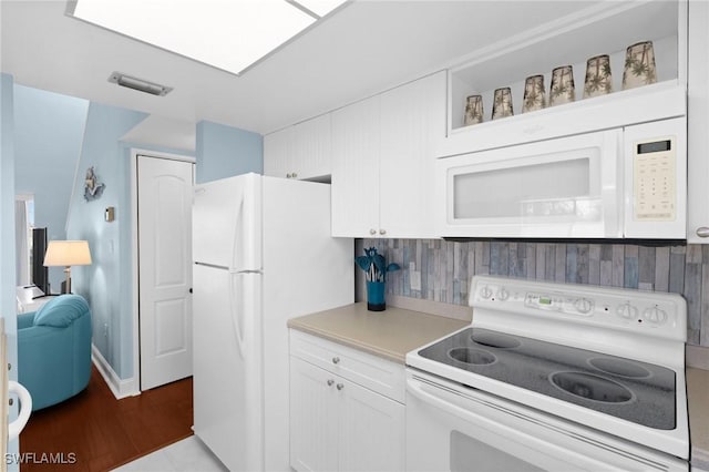 kitchen featuring white appliances, white cabinets, and tasteful backsplash