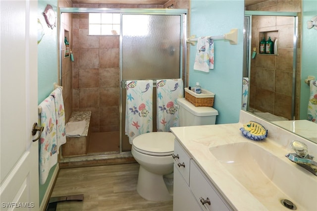 bathroom featuring hardwood / wood-style floors, an enclosed shower, vanity, and toilet