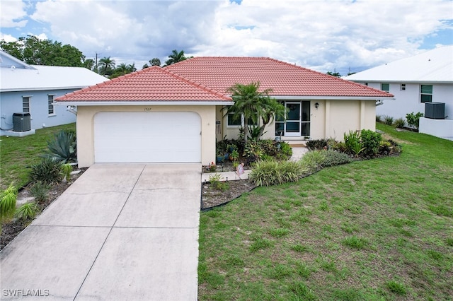 view of front facade with a garage, central air condition unit, and a front lawn