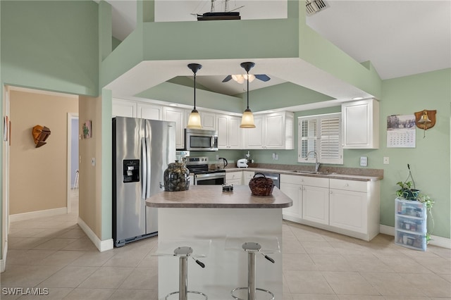 kitchen with appliances with stainless steel finishes, light tile patterned floors, white cabinetry, and sink