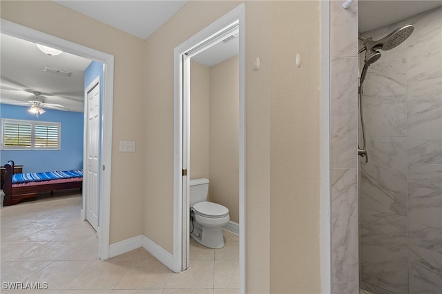 bathroom with tiled shower, tile patterned floors, toilet, and ceiling fan