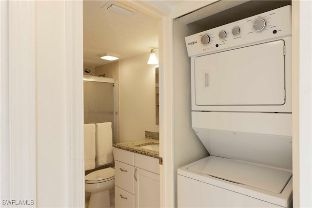 laundry room featuring sink and stacked washer / drying machine