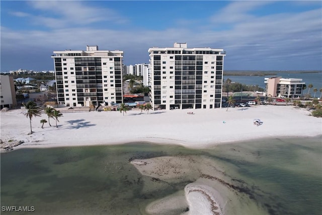 view of building exterior with a beach view and a water view