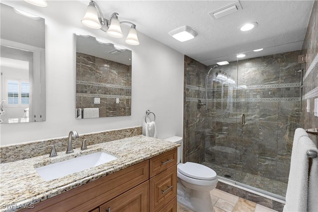 bathroom featuring toilet, vanity, a textured ceiling, and a shower with shower door