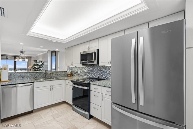 kitchen featuring tasteful backsplash, white cabinetry, appliances with stainless steel finishes, dark stone countertops, and sink