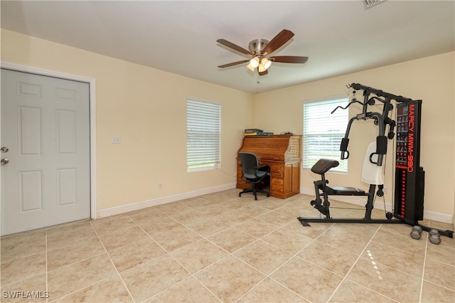 workout room with ceiling fan and light tile patterned floors