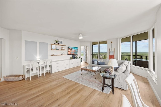 living room featuring ceiling fan and light wood-type flooring