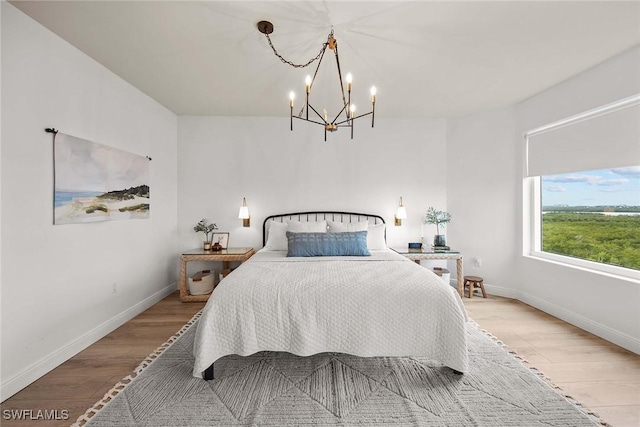 bedroom featuring light wood-type flooring and a notable chandelier