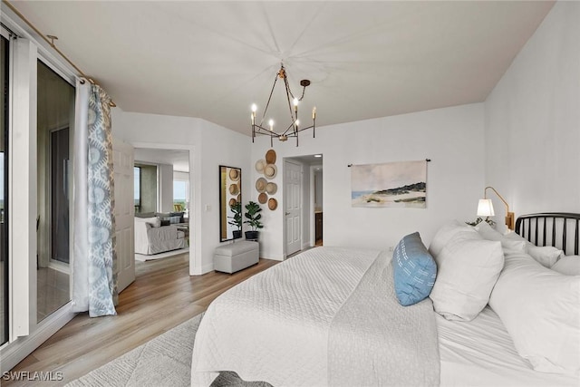 bedroom with light hardwood / wood-style floors and a notable chandelier