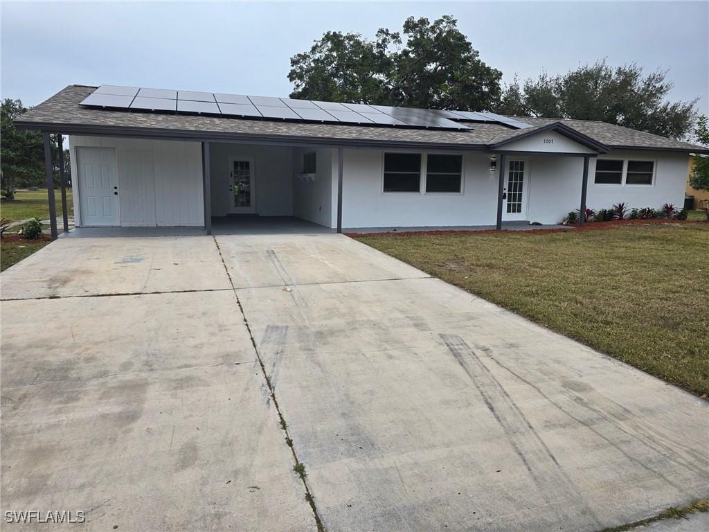 ranch-style house featuring a front lawn and a carport