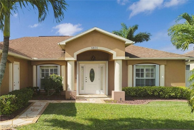 entrance to property with a lawn